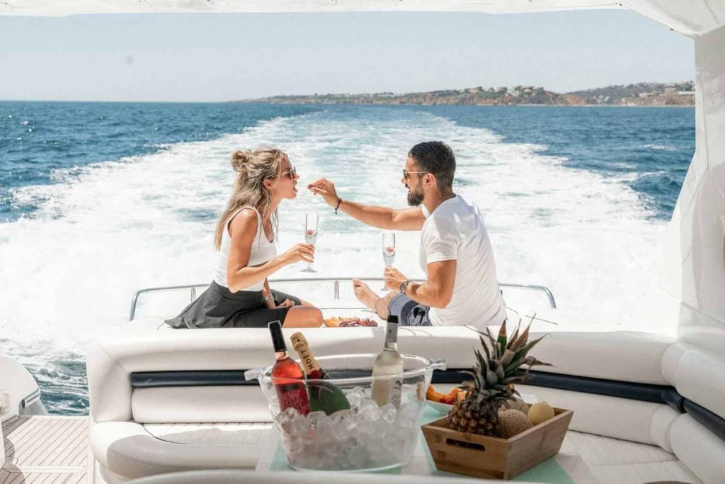 A couple enjoys a romantic meal with champagne on the aft deck of a yacht