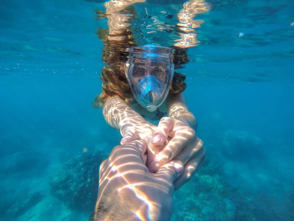 Beautiful woman under water before dive to coral reef, woman snorkeling in blue mask on summer vacation